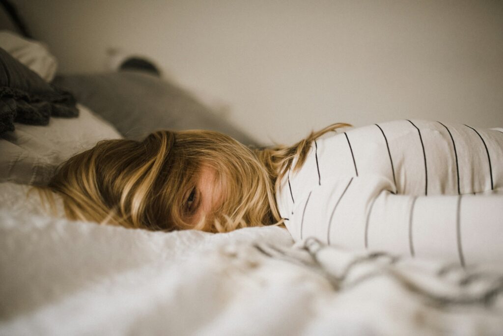 women lying on bed with fever